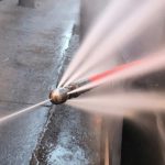 High-pressure water spray nozzle demonstrating hydro jet drain cleaning with multiple forceful water streams.
