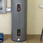 Gray water heater with viewing panels in a utility area, showcasing Guardian Plumbing and Drain’s maintenance focus.